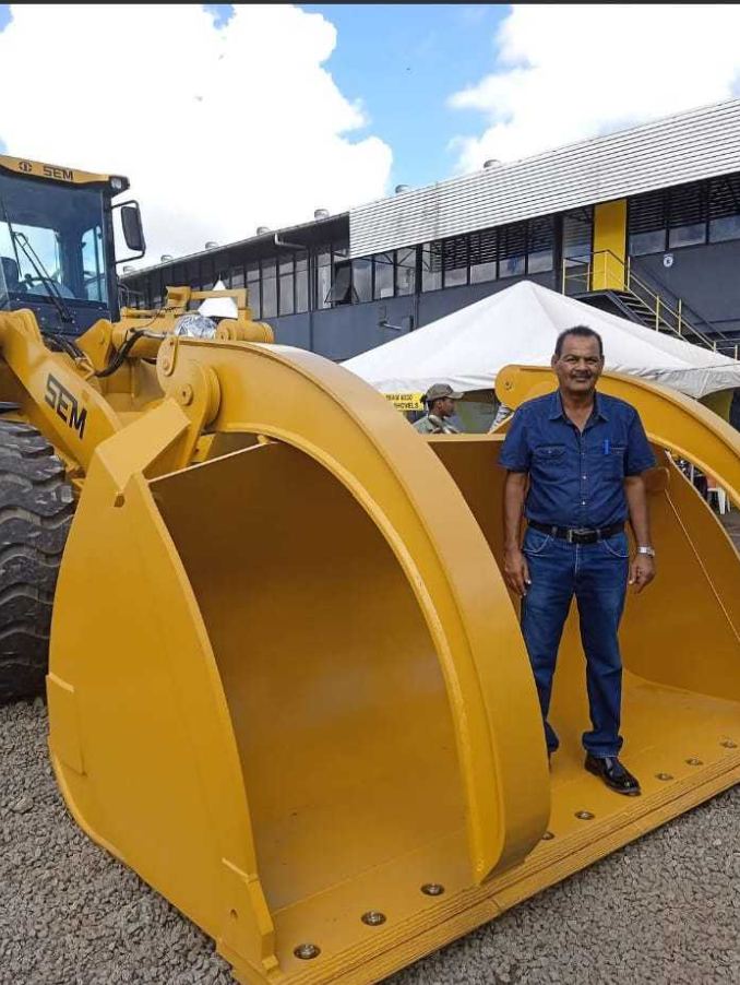 Mohamed Haroenkhan Abdul standing in the bucket of a SEM construction vehicle