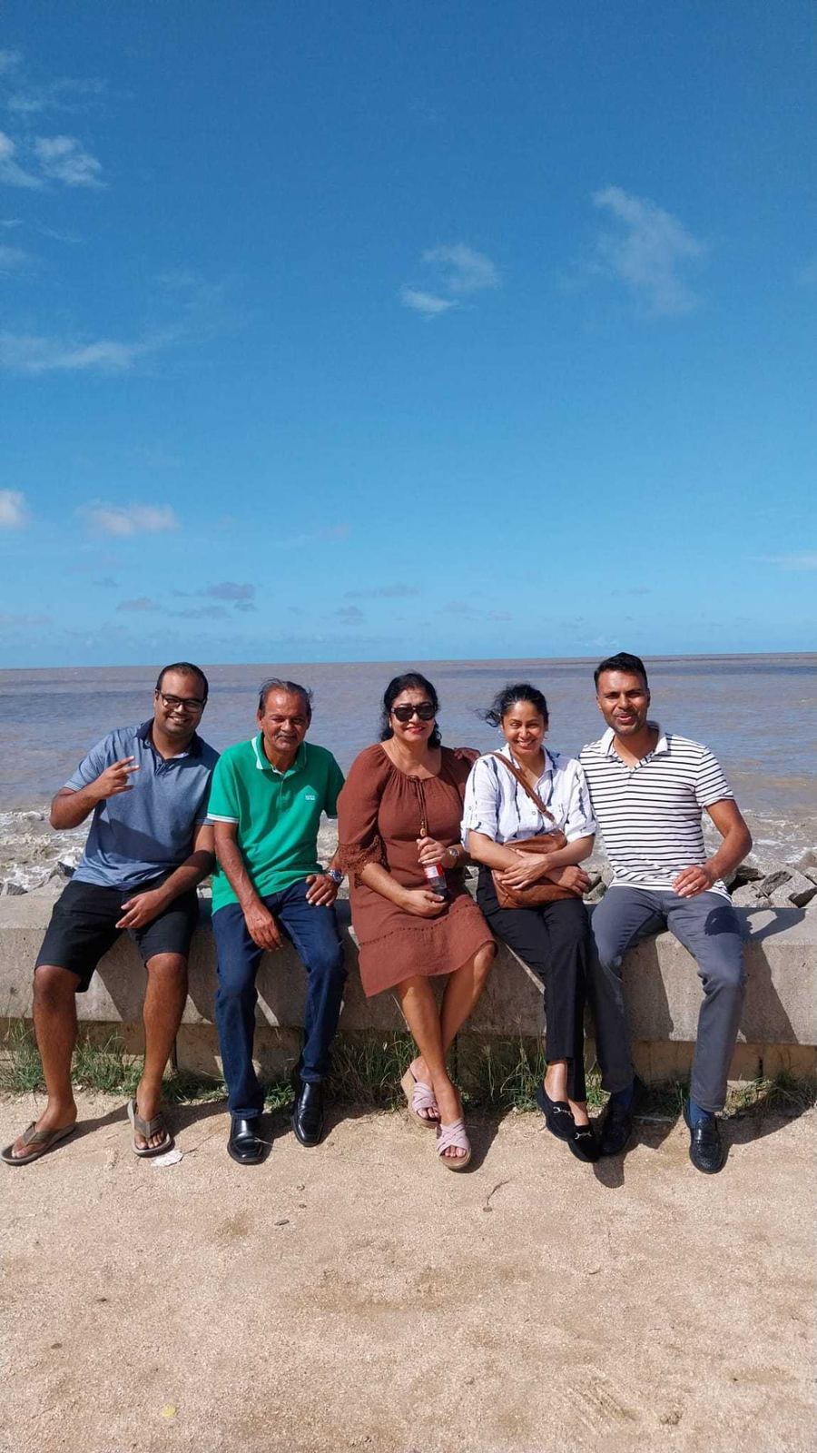 Family sitting together along the seawall